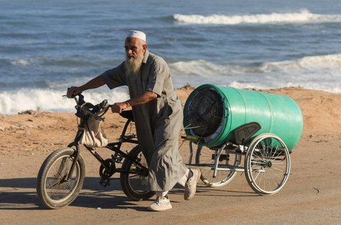 Ein Palästinenser flüchtet mit seinem Fahrrad aus Gaza-Stadt.