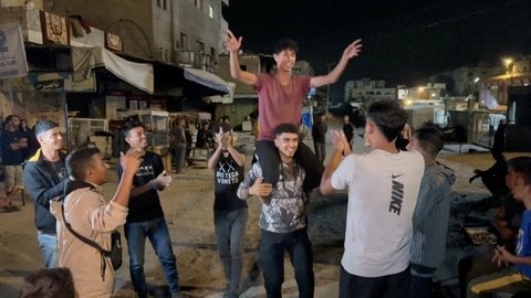 Palästinenser feiern auf einer Straße in Khan Yunis im südlichen Gazastreifen.