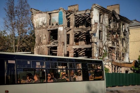 Ein Nahverkehrsbus fährt an einem Wohnhaus vorbei, das im Juli dieses Jahres während des russischen Angriffs auf die Ukraine in der Frontstadt Kramatorsk in der Ukraine zerstört wurde (Symbolbild).