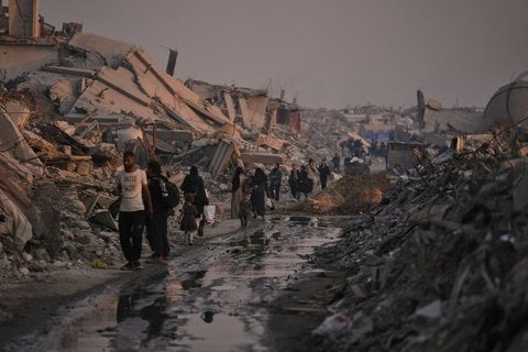Palästinenser gehen durch die Ruinen, die die israelische Luft- und Bodenoffensive in der Stadt Gaza hinterlassen hat.