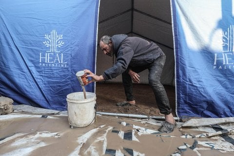 Palästinenser beim Versuch, sein überflutetes Zelt trocken zu legen.