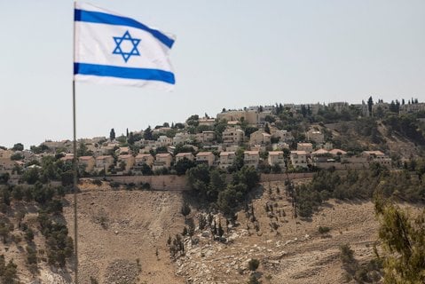 Eine israelische Flagge ist vor einer Siedlung im Westjordanland zu sehen.