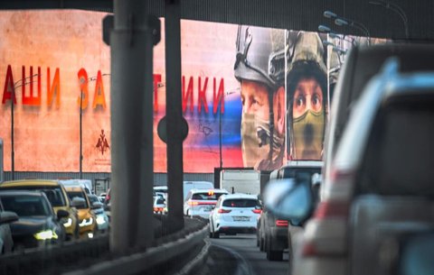 Autos fahren am 23. Dezember 2025 in Moskau an einer riesigen Werbetafel vorbei, die russischen Soldaten gewidmet ist und auf der „Unsere Verteidiger” zu lesen ist.