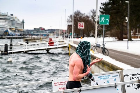 Ein hart gesottener Saunagänger verlässt nach einer Abkühlung die Innenförde in Strande in Schleswig-Holstein.