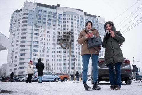 Einheimische stehen am Schauplatz eines Drohnenangriffs, bei dem ein Wohngebiet im Osten von Kiew getroffen und eine Person getötet wurde.