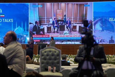 Journalisten arbeiten, während das pakistanische Staatsfernsehen das Treffen zwischen US-Vizepräsident J.D. Vance und dem pakistanischen Premierminister Shehbaz Sharif in einem Medienzentrum für die Berichterstattung über die US-Iran-Gespräche in Islamabad überträgt.