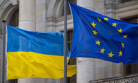 Die Nationalflagge der Ukraine und die Flagge der EU wehen im Wind.